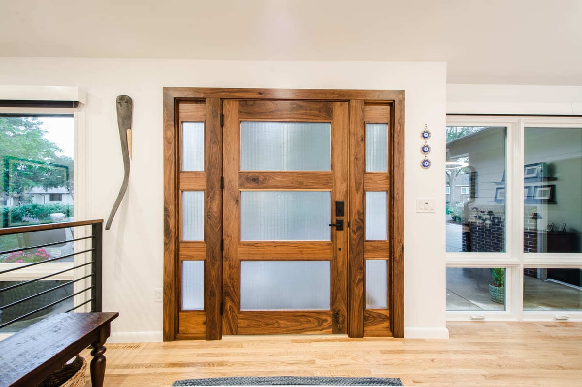 Applewood, CO renovation front entry with custom wood door and frosted glass panels by Cillessen Construction
