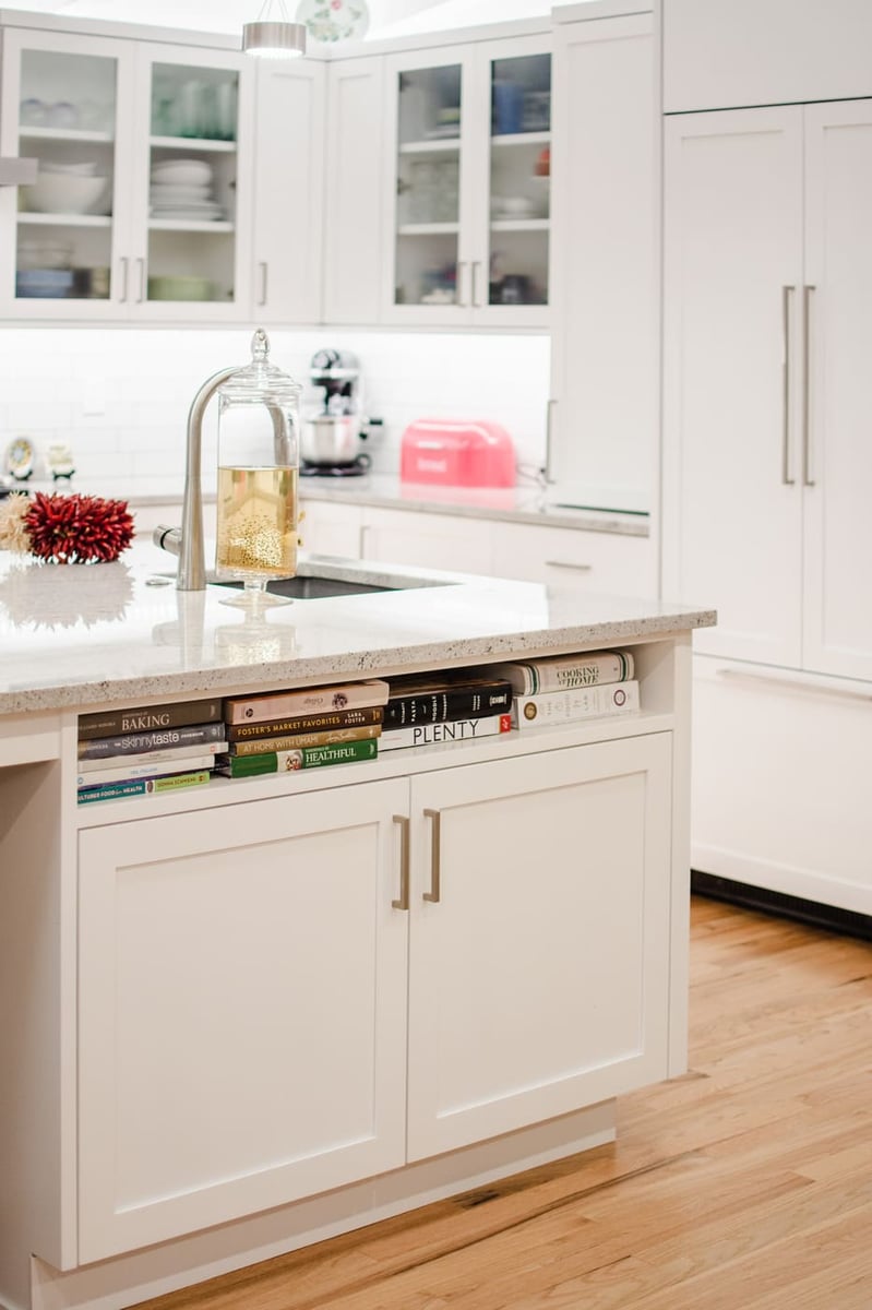 Applewood, CO renovation kitchen island detail with quartz counters, storage, and white cabinetry by Cillessen Construction