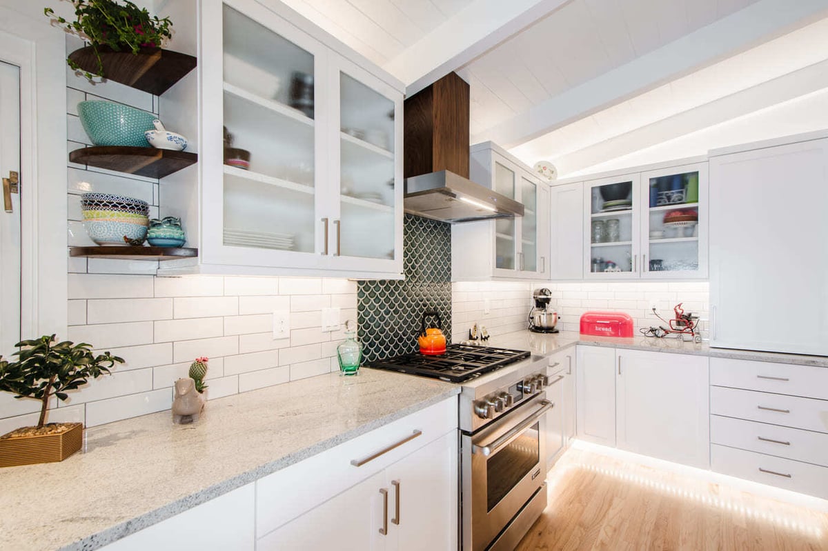 Applewood, CO renovation kitchen with white cabinets, quartz counters, and tile backsplash by Cillessen Construction