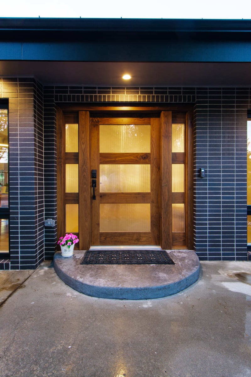 Applewood, CO renovation modern front entry with wood door and brick exterior by Cillessen Construction