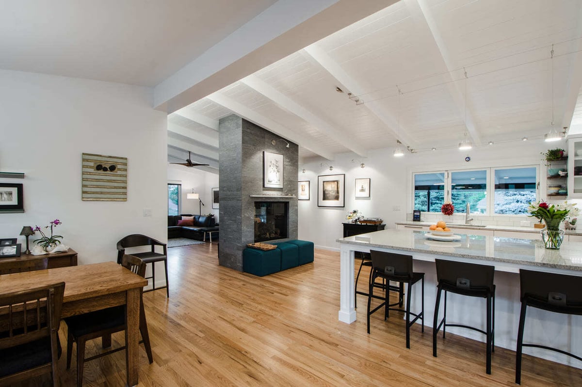 Applewood, CO renovation open kitchen and living area with island seating and fireplace by Cillessen Construction