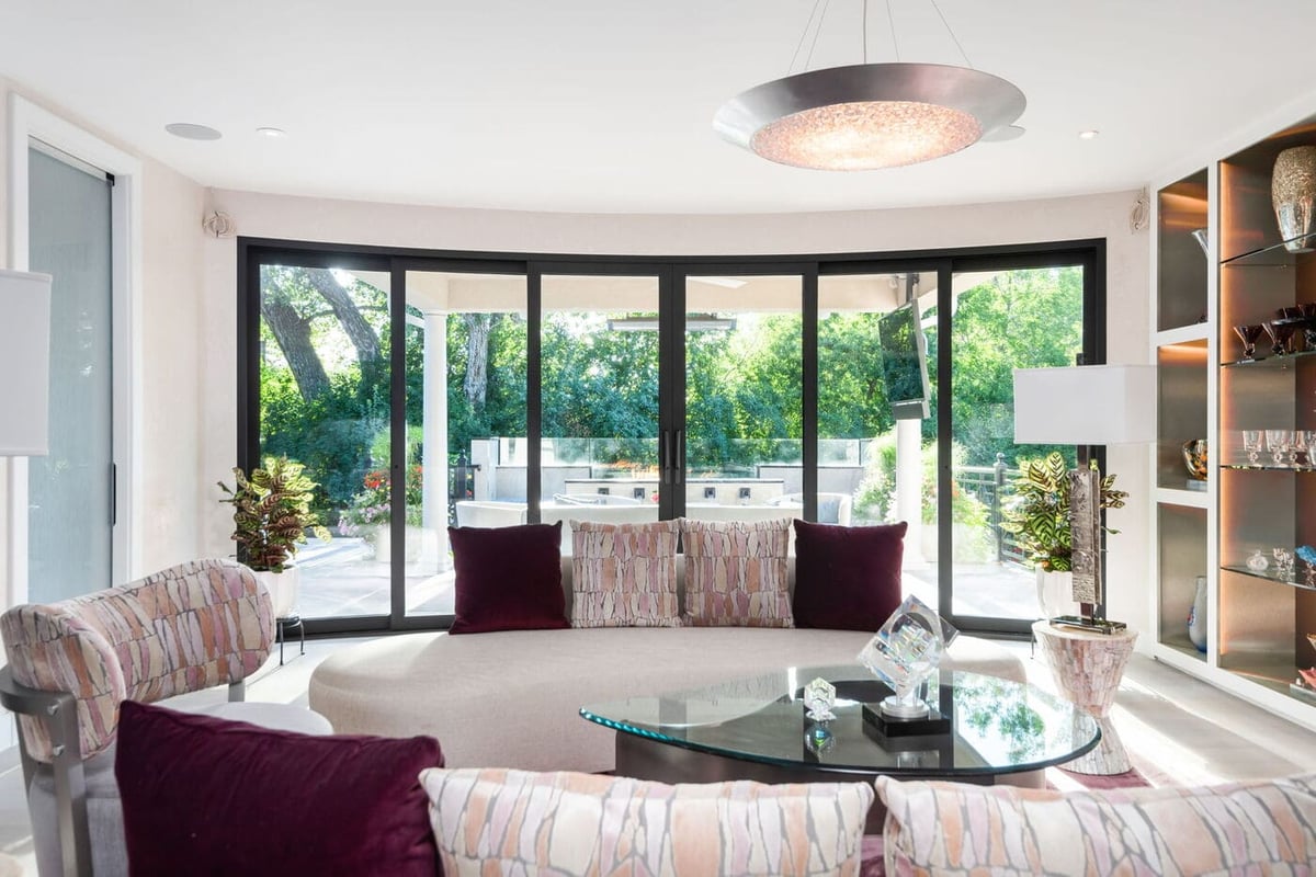 Greenwood Village, CO bright living room with curved seating and wall of glass doors, by Cillessen Construction