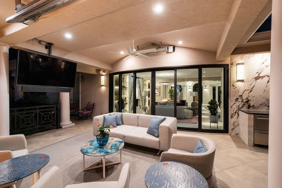 Greenwood Village, CO covered patio lounge with TV, seating, and sliding glass doors, by Cillessen Construction
