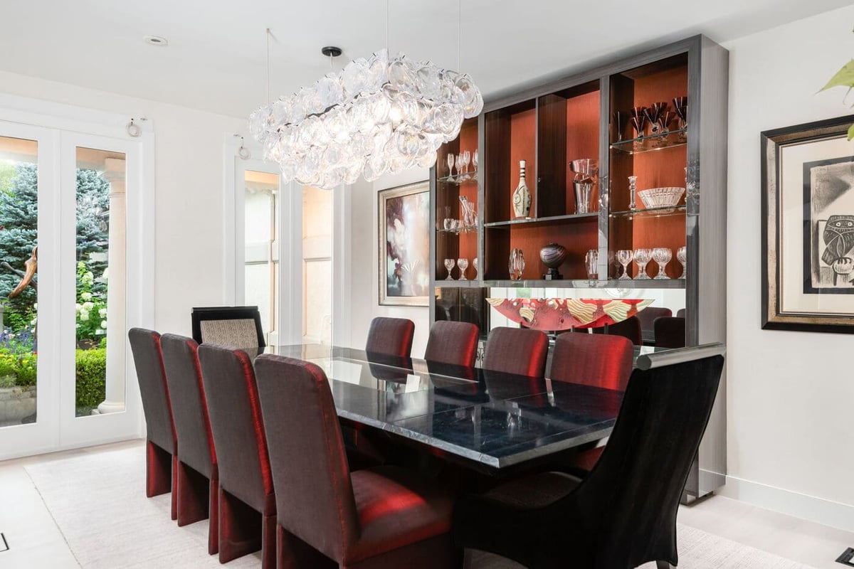 Greenwood Village, CO dining room with glass chandelier, dark table, and built-in display cabinetry by Cillessen Construction