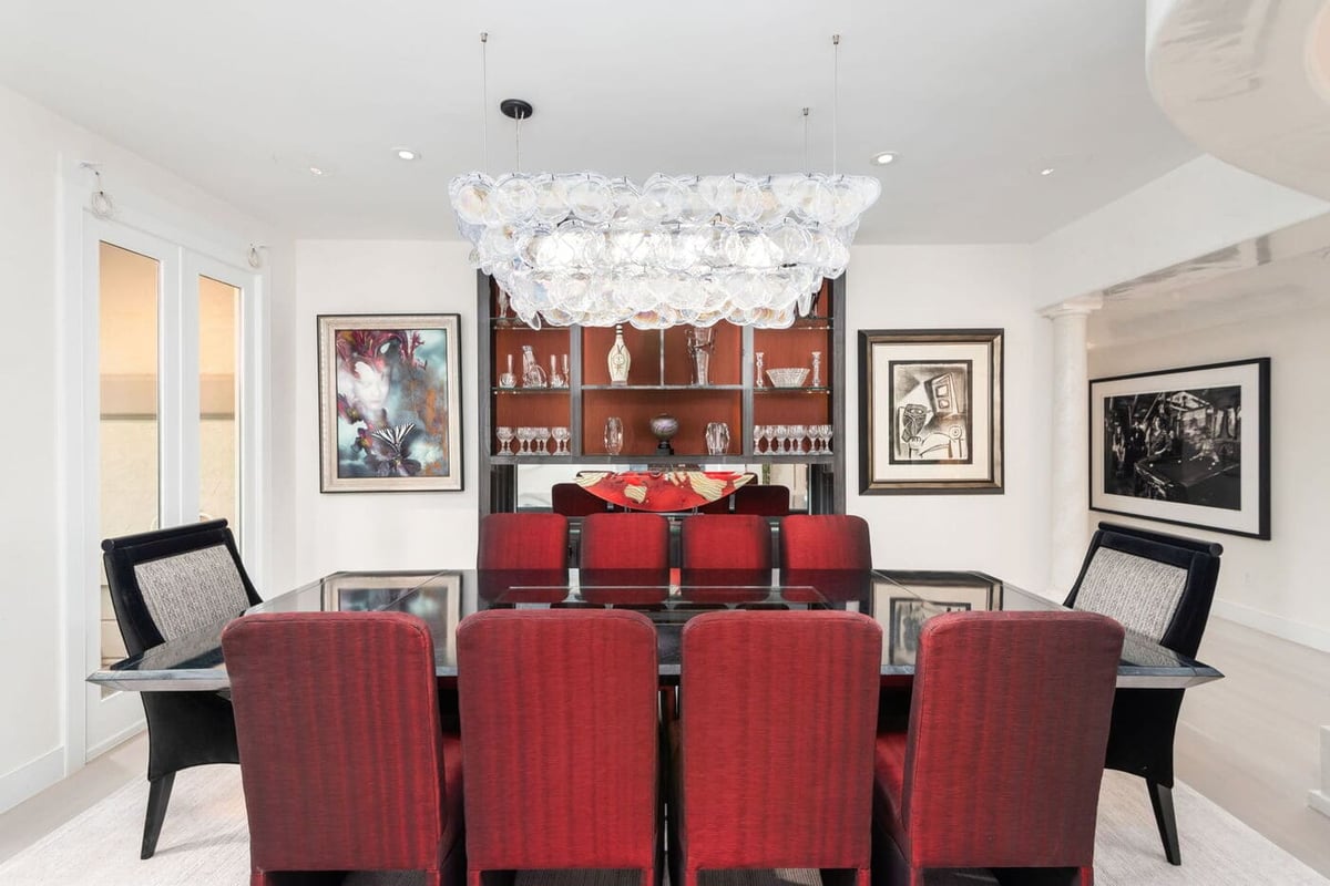 Greenwood Village, CO dining room with glass chandelier, red chairs, and display cabinetry by Cillessen Construction