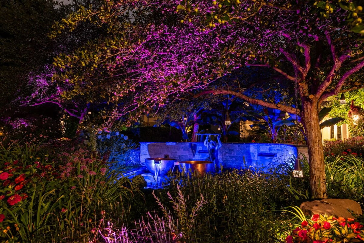 Greenwood Village, CO garden at night with colorful landscape lighting and water feature, by Cillessen Construction