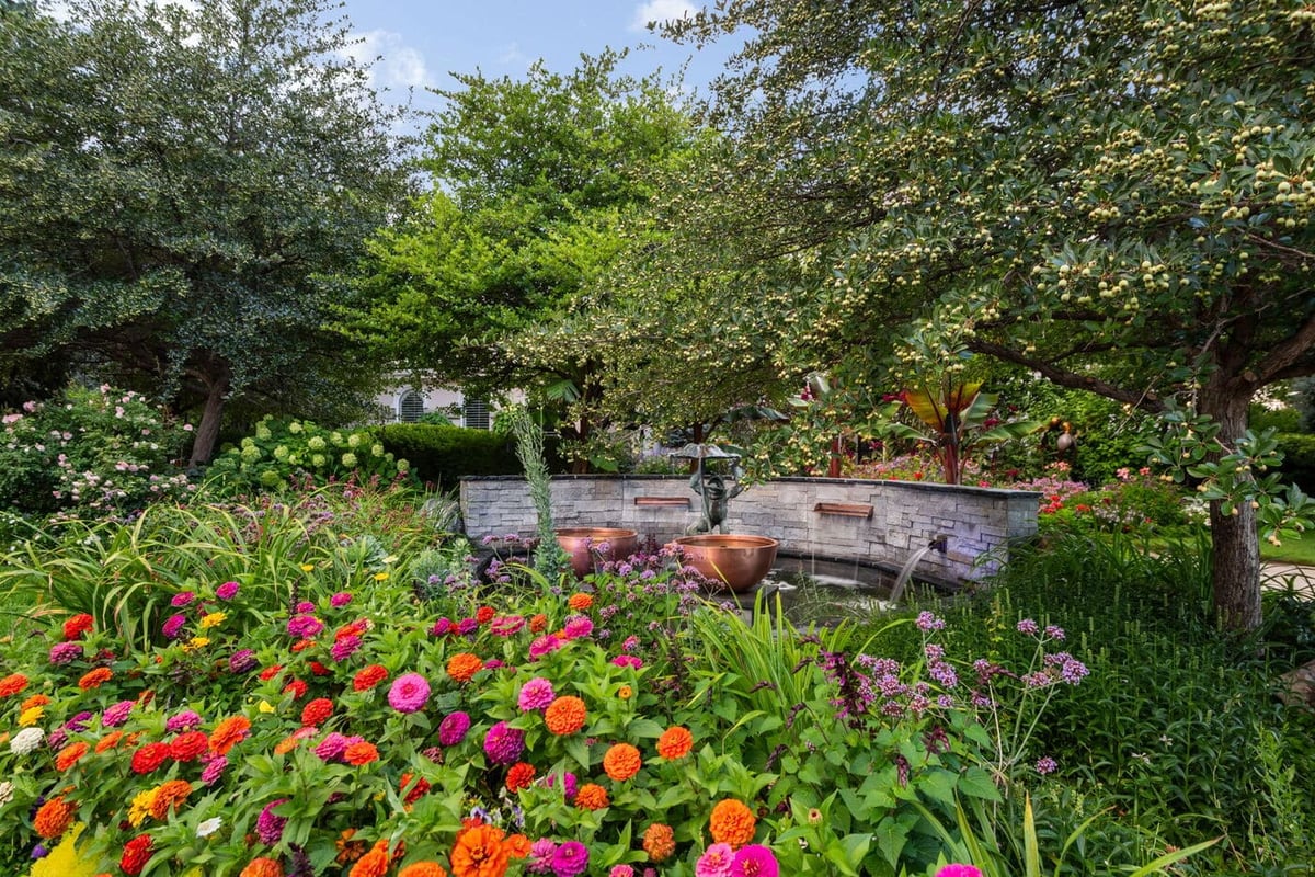 Greenwood Village, CO garden with colorful flowers, trees, and water feature by Cillessen Construction renovation
