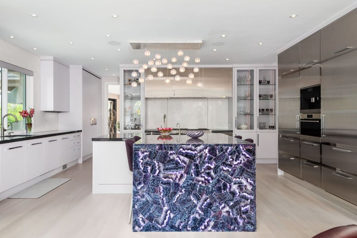 Greenwood Village, CO kitchen renovation with purple stone island, modern lighting, and sleek cabinetry by Cillessen Construction