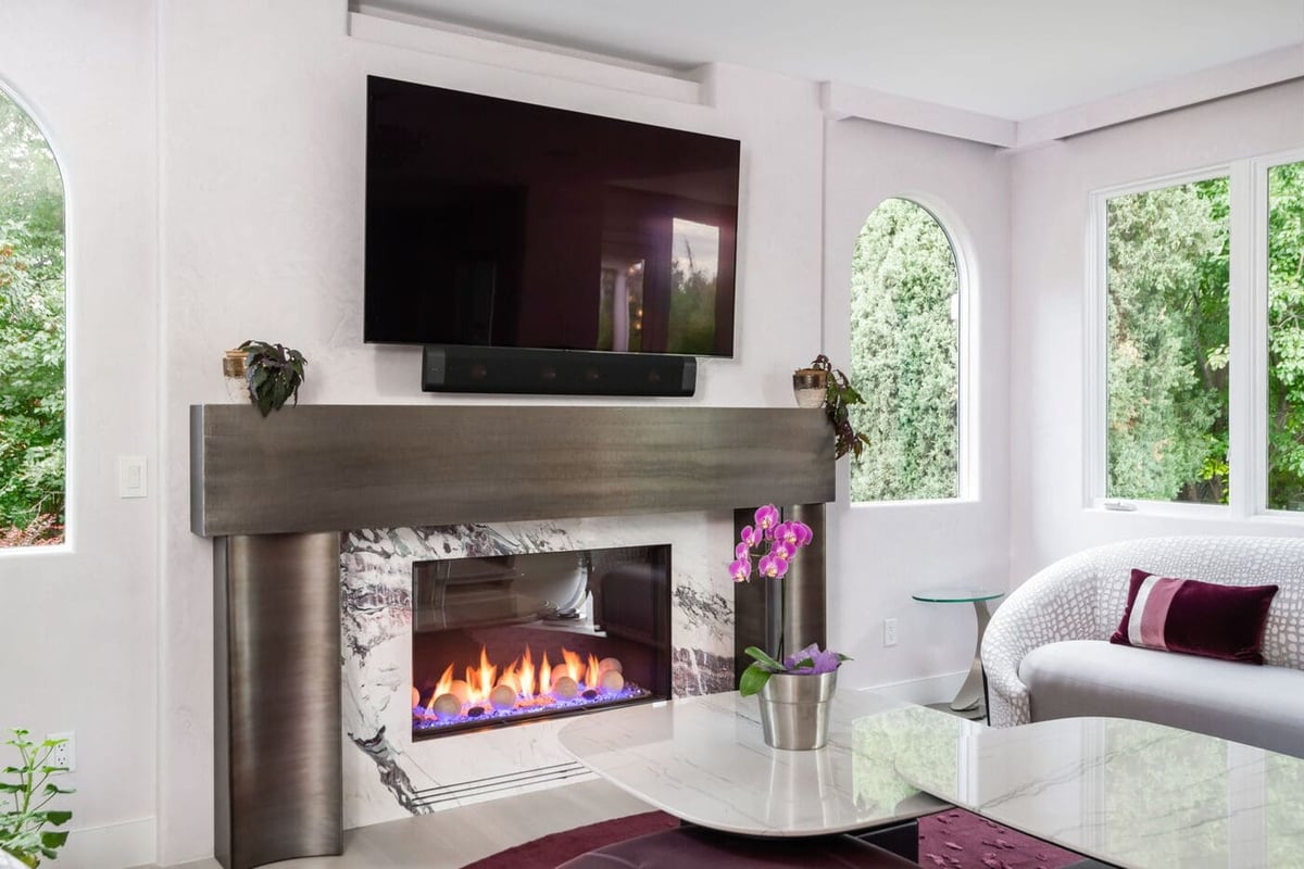 Greenwood Village, CO living room fireplace detail with marble surround and modern seating by Cillessen Construction