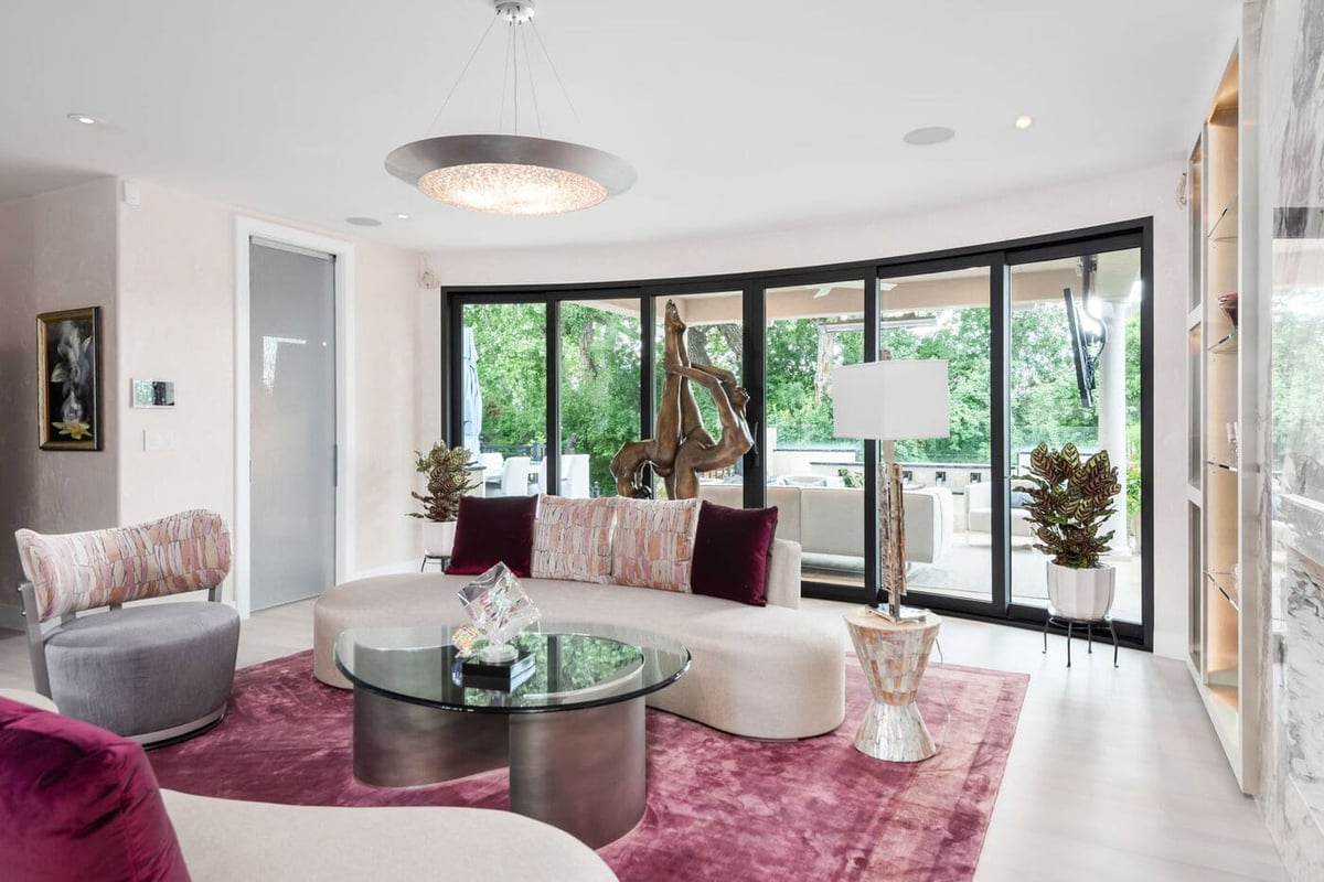 Greenwood Village, CO living room with curved seating, glass coffee table, and outdoor views by Cillessen Construction