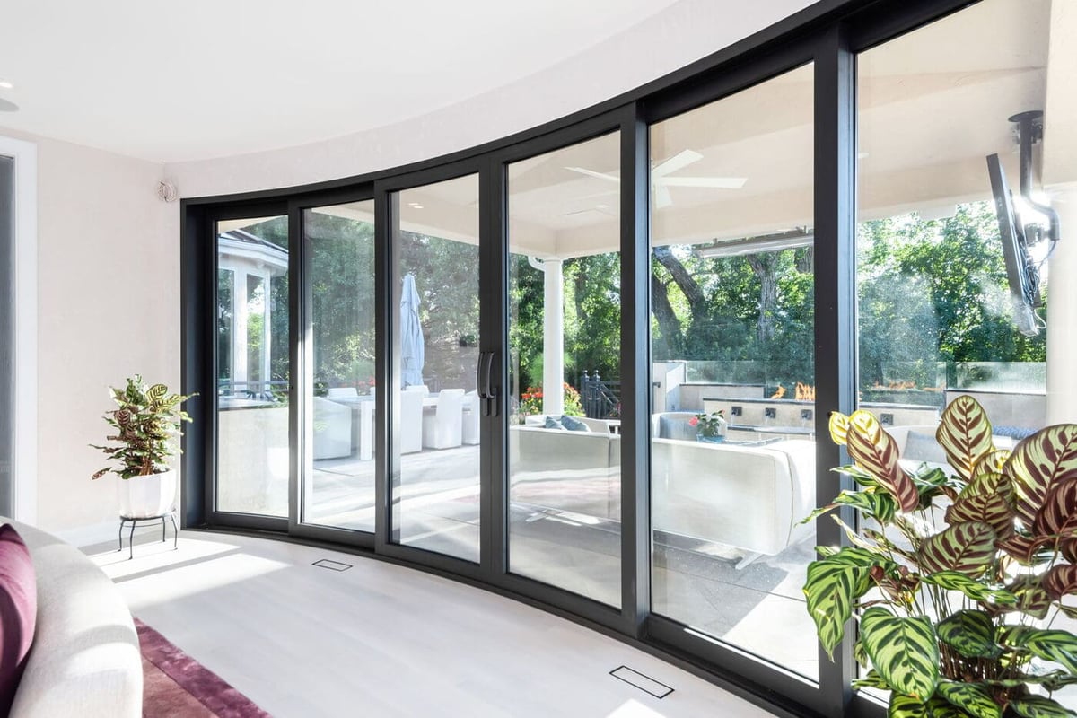 Greenwood Village, CO living room with curved sliding glass doors opening to patio, renovated by Cillessen Construction