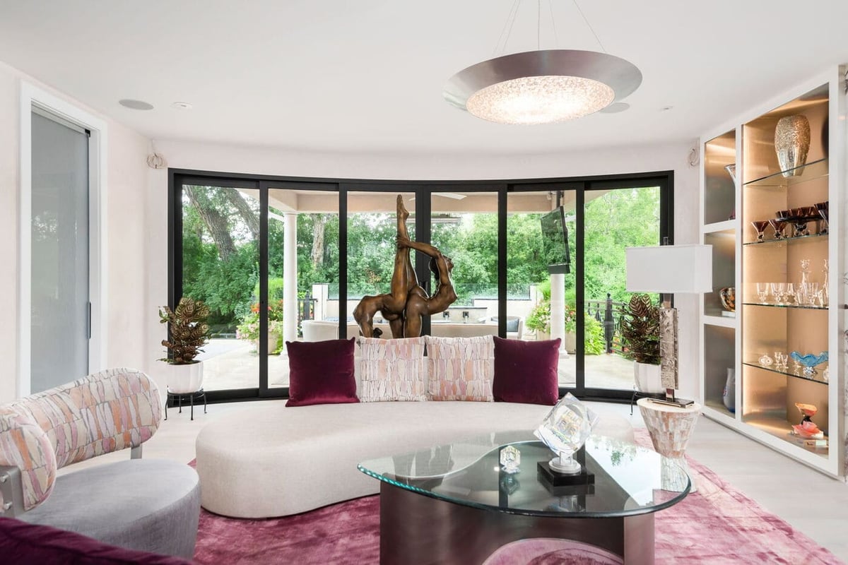 Greenwood Village, CO living room with curved sofa, glass doors, and patio views by Cillessen Construction renovation