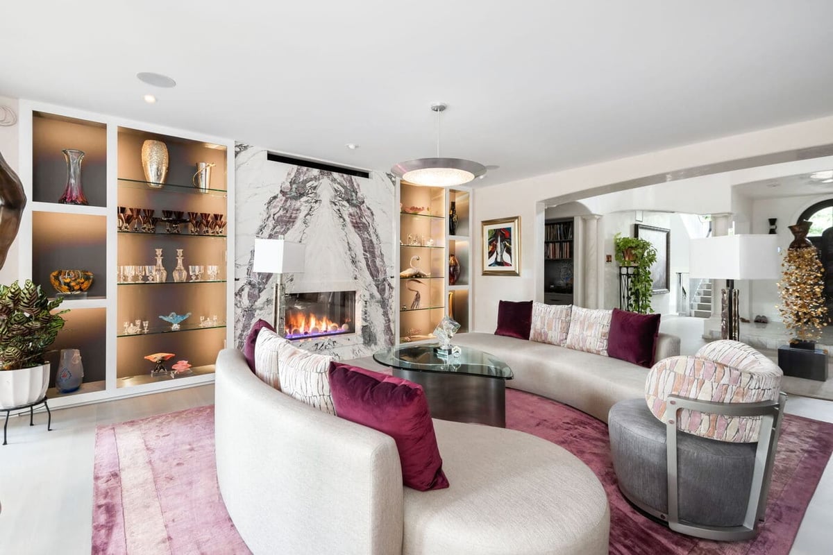 Greenwood Village, CO living room with curved sofas, fireplace, and display shelving by Cillessen Construction