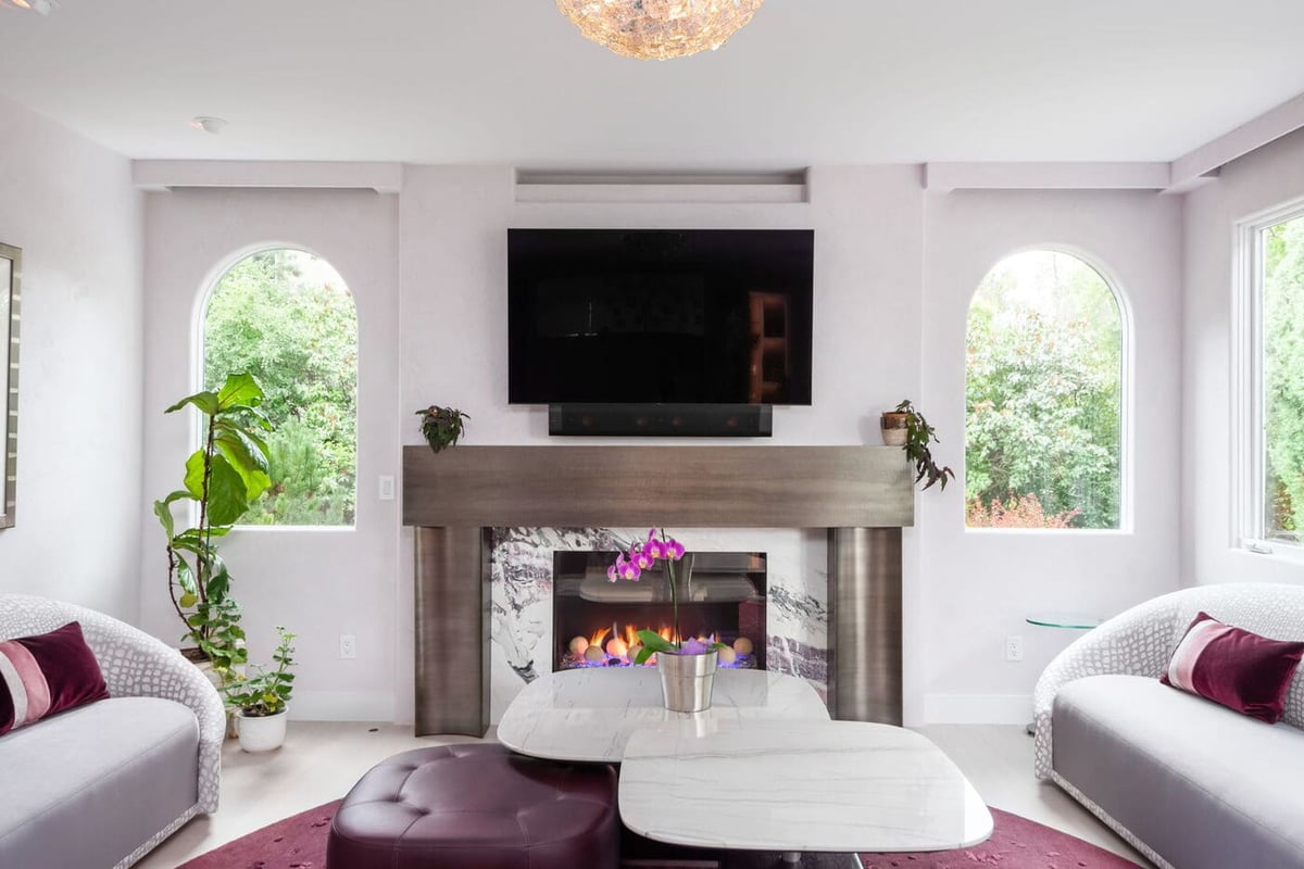 Greenwood Village, CO living room with modern fireplace, TV, and curved seating by Cillessen Construction renovation