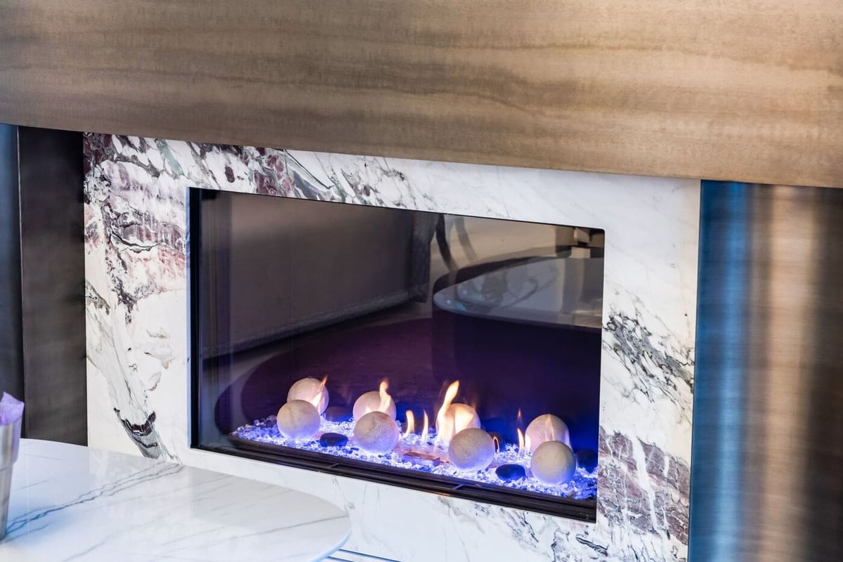 Greenwood Village, CO modern marble fireplace with glass front and blue flames, renovation by Cillessen Construction