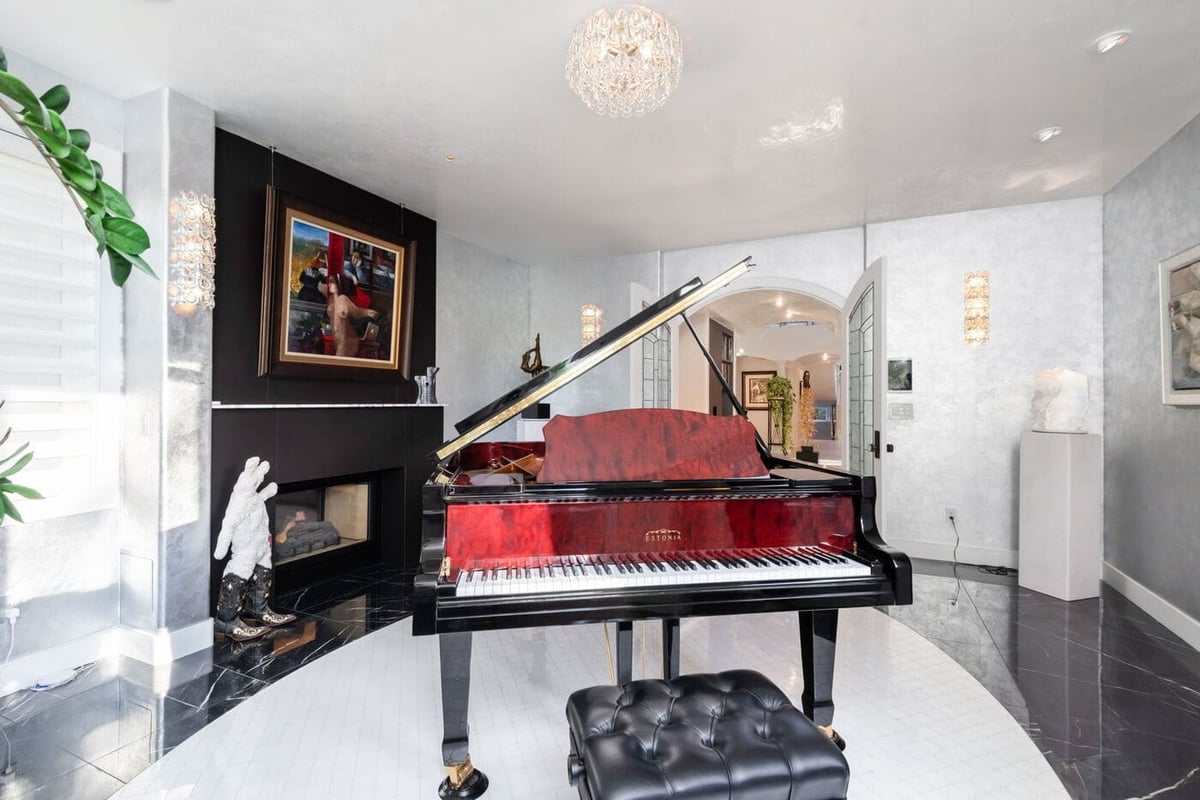 Greenwood Village, CO music room with grand piano and black fireplace, renovated by Cillessen Construction