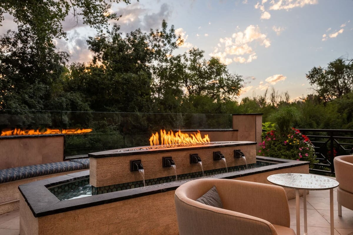 Greenwood Village, CO patio fire and water feature with seating at sunset, renovated by Cillessen Construction