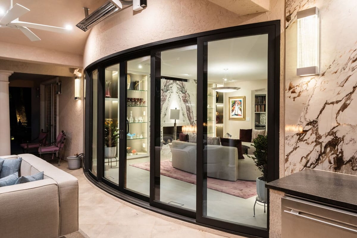 Greenwood Village, CO patio with curved glass doors opening to living room, renovation by Cillessen Construction