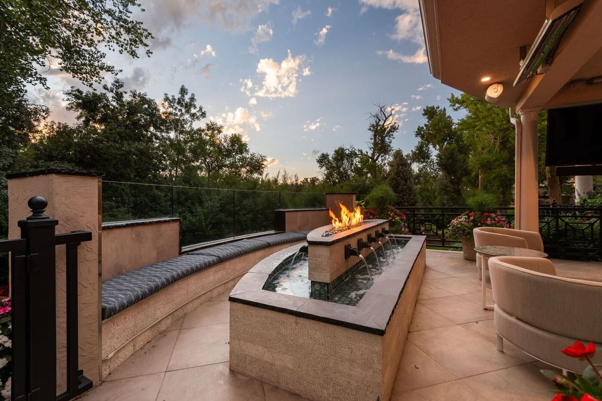 Greenwood Village, CO patio with fire feature and water element at sunset, renovated by Cillessen Construction