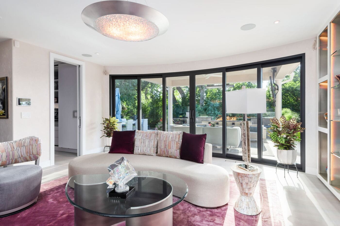 Greenwood Village, CO living room with curved sofa and patio views through glass doors, by Cillessen Construction