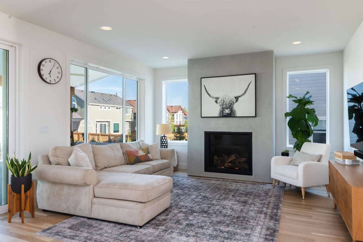Bright living room with sectional sofa, fireplace, and wall art in custom home in Louisville, CO by Cillessen Construction