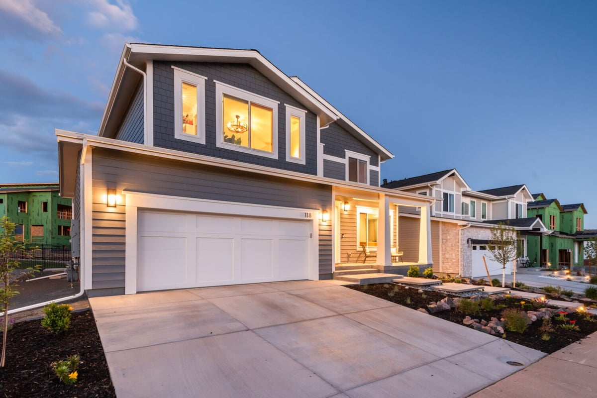 Wide exterior view of custom home with driveway, garage, and evening lighting in Louisville, CO by Cillessen Construction