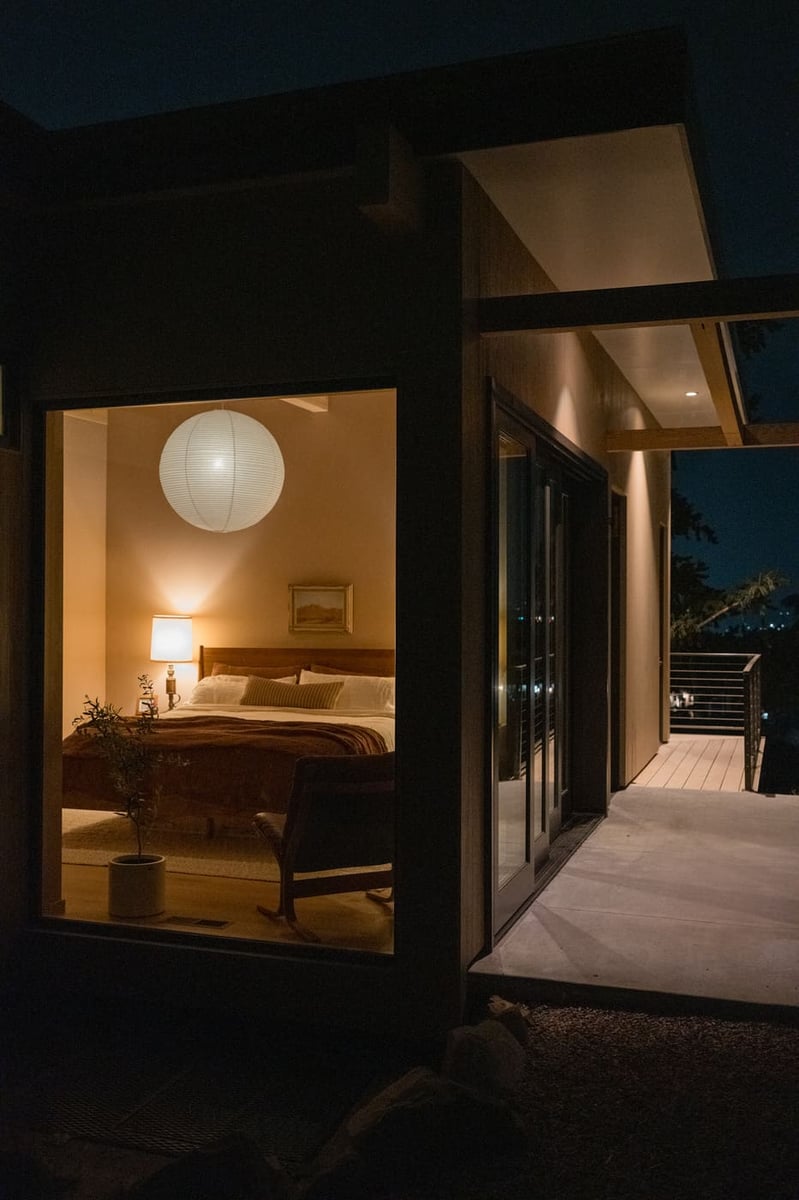 Bedroom view through large window at night with soft lighting in Arvada, CO pop top renovation by Cillessen Construction