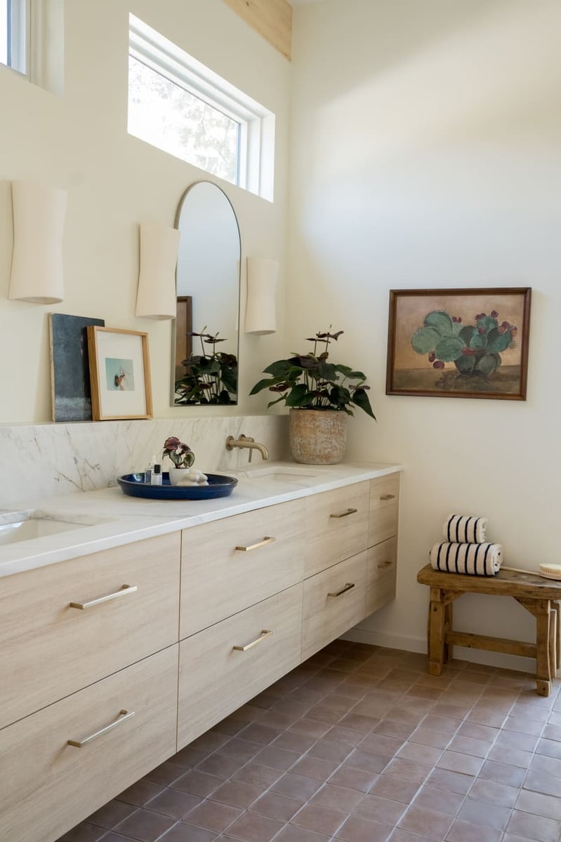 Bright bathroom with double vanity, marble counter, and decor in Arvada, CO pop top renovation by Cillessen Construction