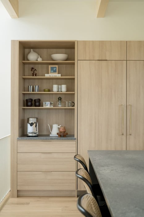 Built-in wood shelving and cabinets with decor and appliances in Arvada, CO pop top renovation by Cillessen Construction