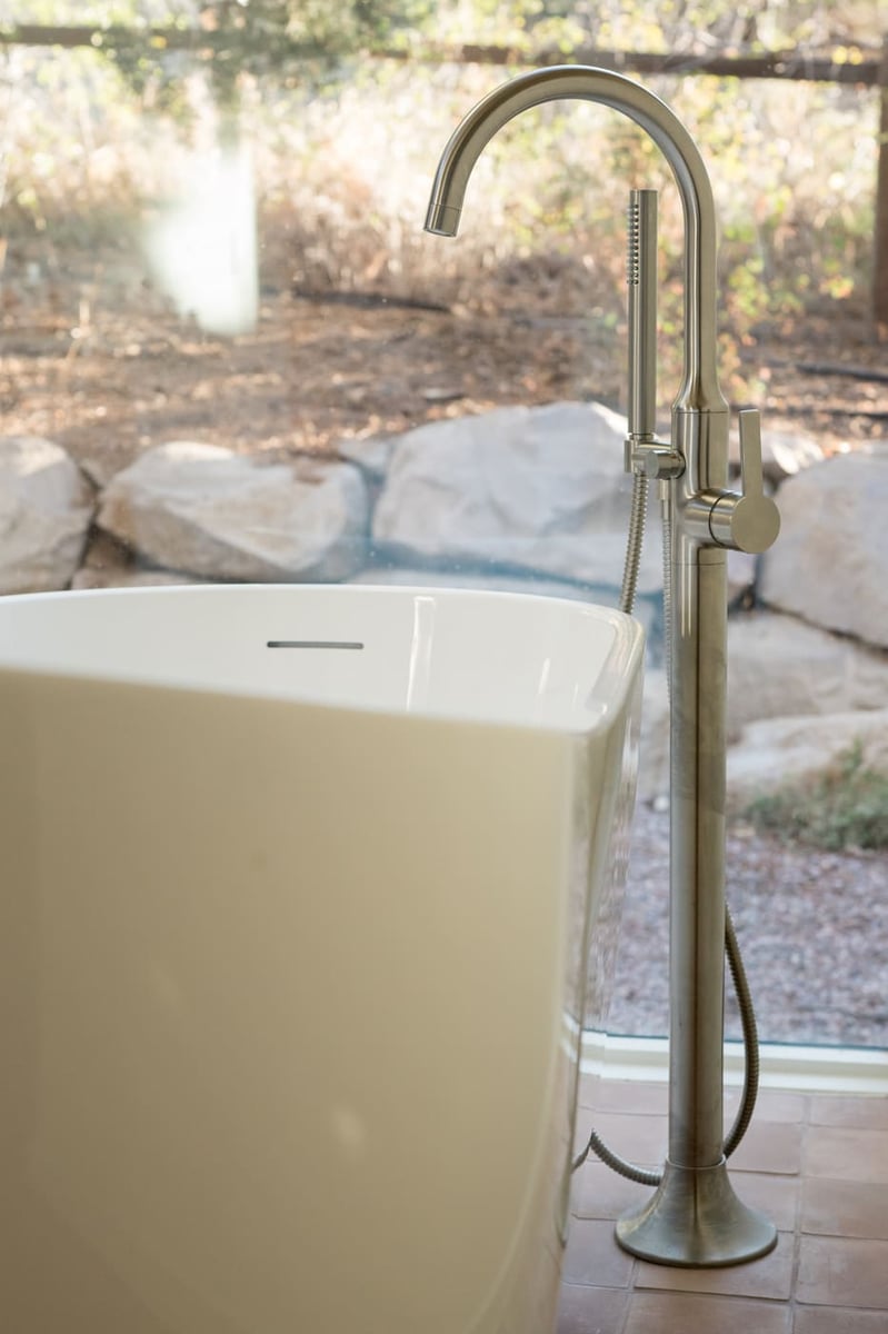 Close-up of freestanding tub and floor-mounted faucet in Arvada, CO pop top renovation by Cillessen Construction