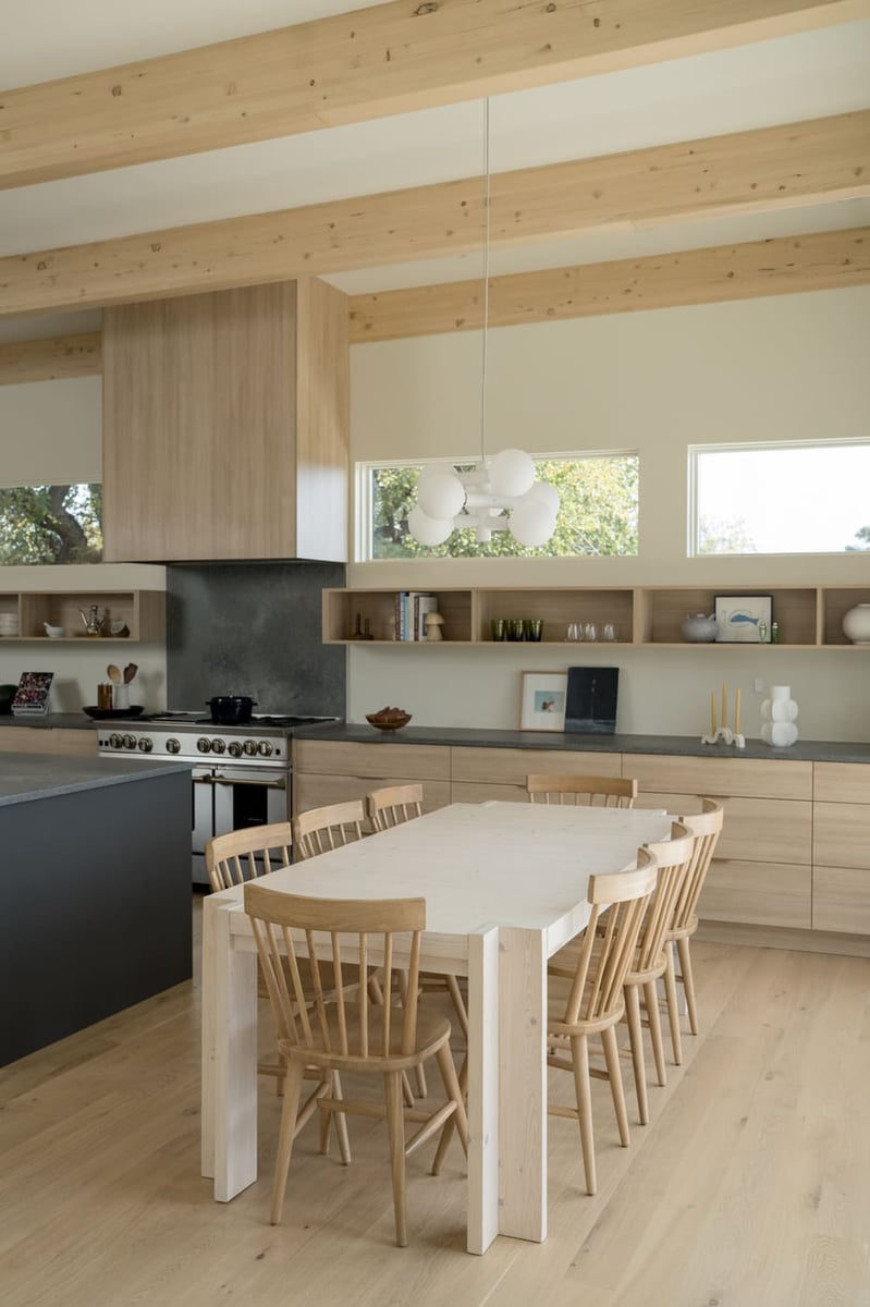 Dining area with exposed beams and modern pendant in Arvada, CO pop top renovation by Cillessen Construction