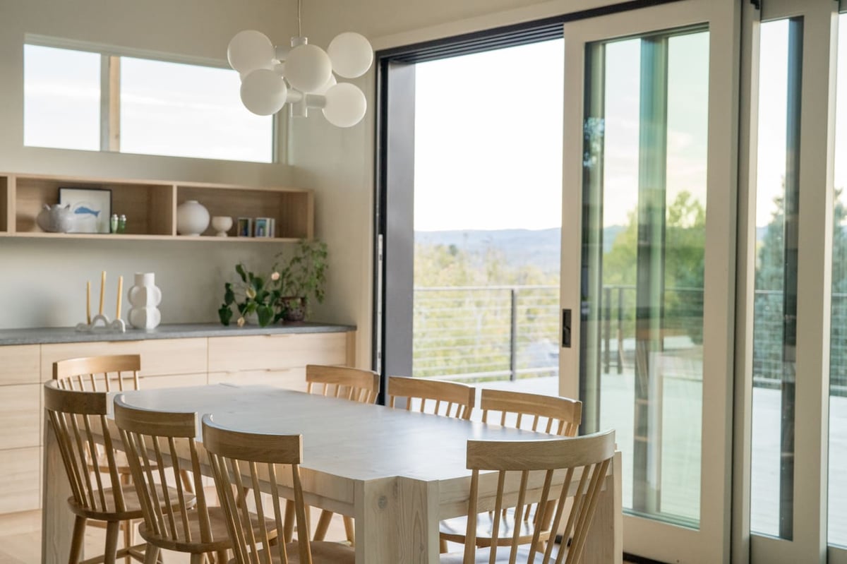 Dining area with sliding glass doors and built-ins in Arvada, CO pop top renovation by Cillessen Construction