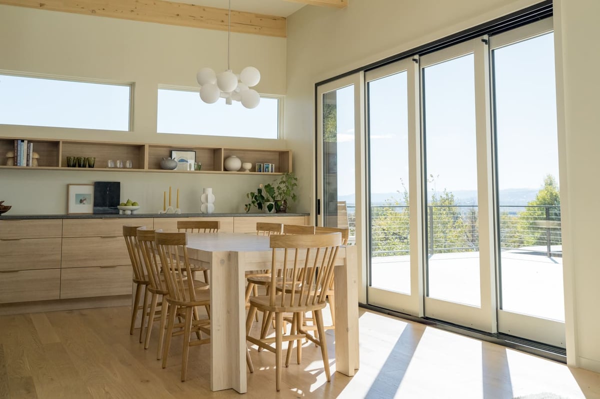 Dining area with wood table and glass doors in Arvada, CO pop top renovation by Cillessen Construction