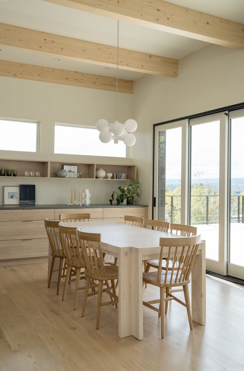 Dining area with wood table, pendant light, and sliding doors in Arvada, CO pop top renovation by Cillessen Construction