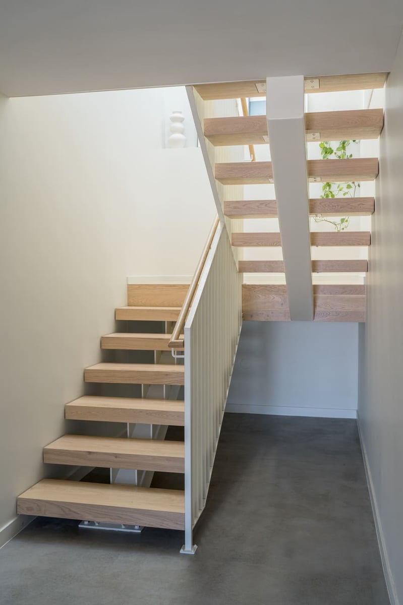 Floating wood staircase with open risers in pop top renovation in Arvada, CO by Cillessen Construction