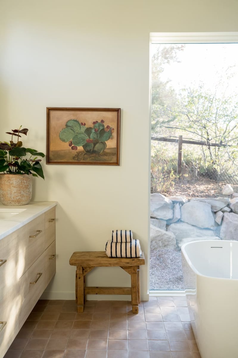 Freestanding tub by window with bench and towels in Arvada, CO pop top renovation by Cillessen Construction