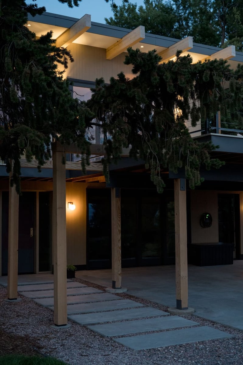 Lower patio with wood posts and covered deck at dusk in Arvada, CO pop top renovation by Cillessen Construction