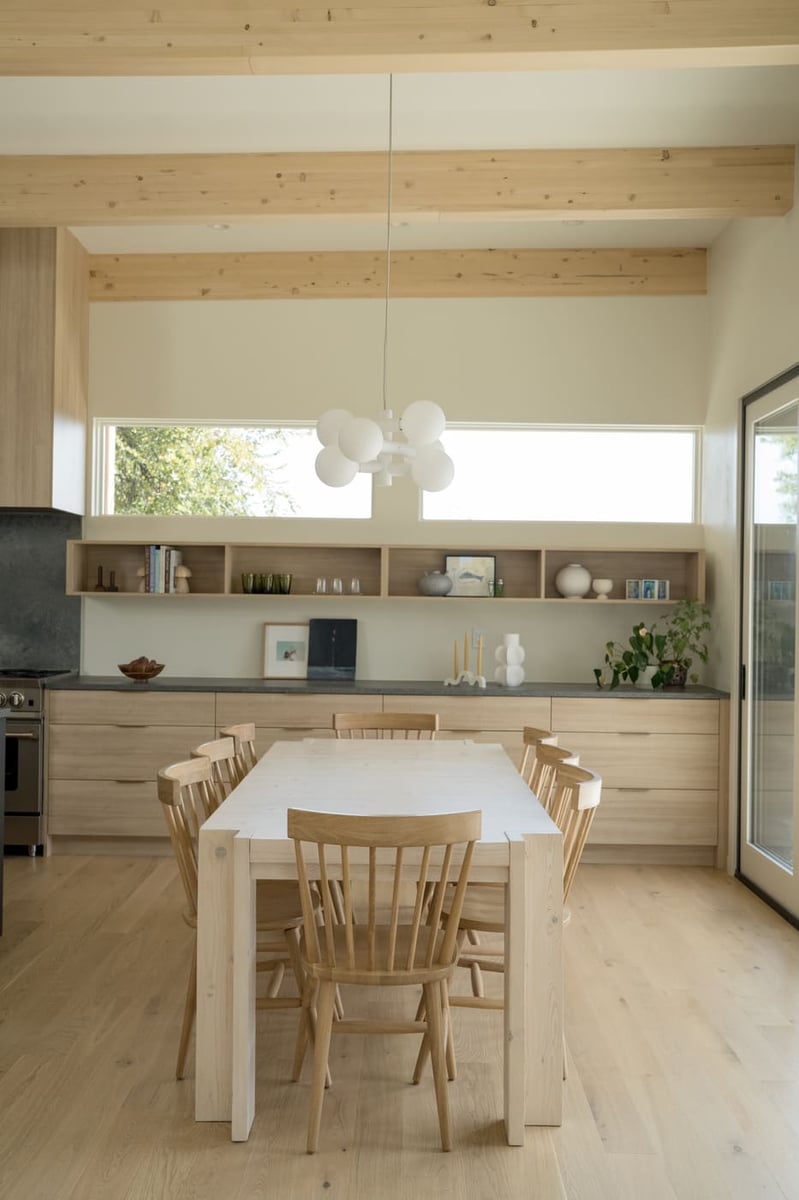 Minimal dining space with built-ins and wood table in Arvada, CO pop top renovation by Cillessen Construction