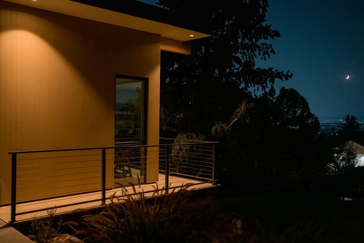 Modern deck at night with warm exterior lighting and crescent moon in Arvada, CO pop top renovation by Cillessen Construction