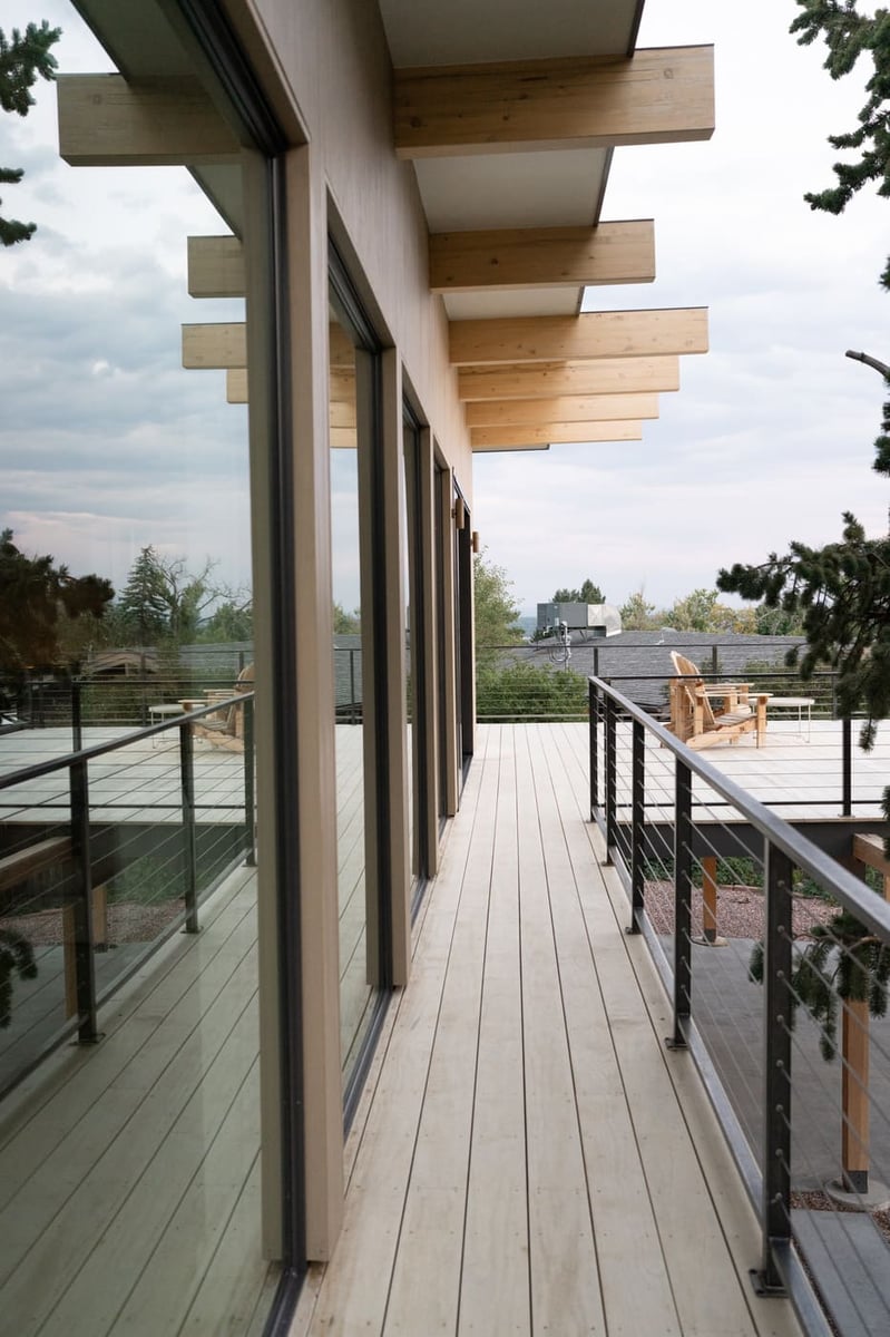 Modern exterior deck with wood beams and railing in Arvada, CO pop top renovation by Cillessen Construction