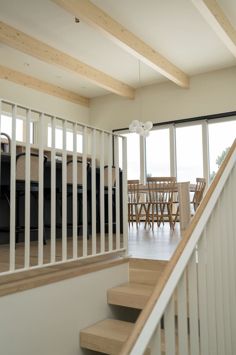 Modern staircase with wood treads and dining area above in pop top renovation in Arvada, CO by Cillessen Construction