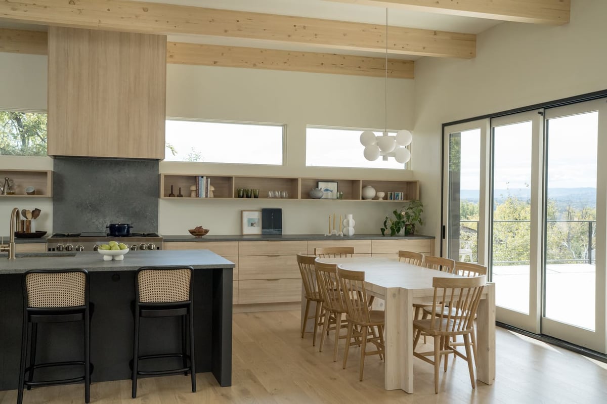 Open kitchen and dining with island seating and large windows in Arvada, CO pop top renovation by Cillessen Construction