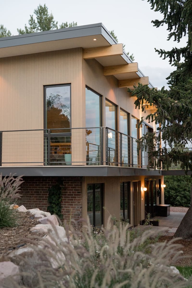 Side view of pop top renovation with deck, lighting, and landscaping in Arvada, CO by Cillessen Construction