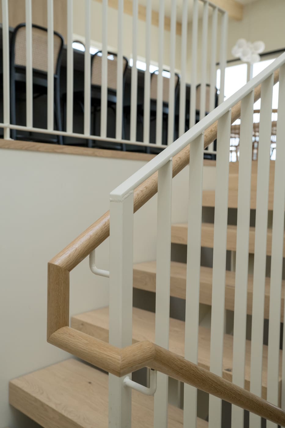 Angled view of modern staircase railing and wood treads in Arvada, CO pop top renovation by Cillessen Construction