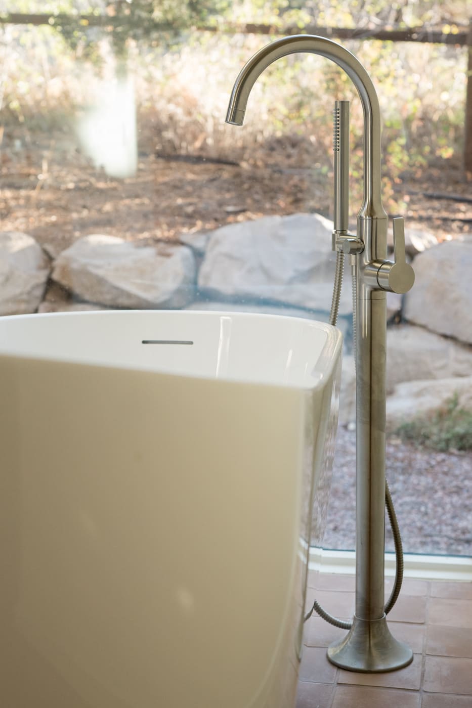 Close-up of freestanding tub and floor-mounted faucet in Arvada, CO pop top renovation by Cillessen Construction