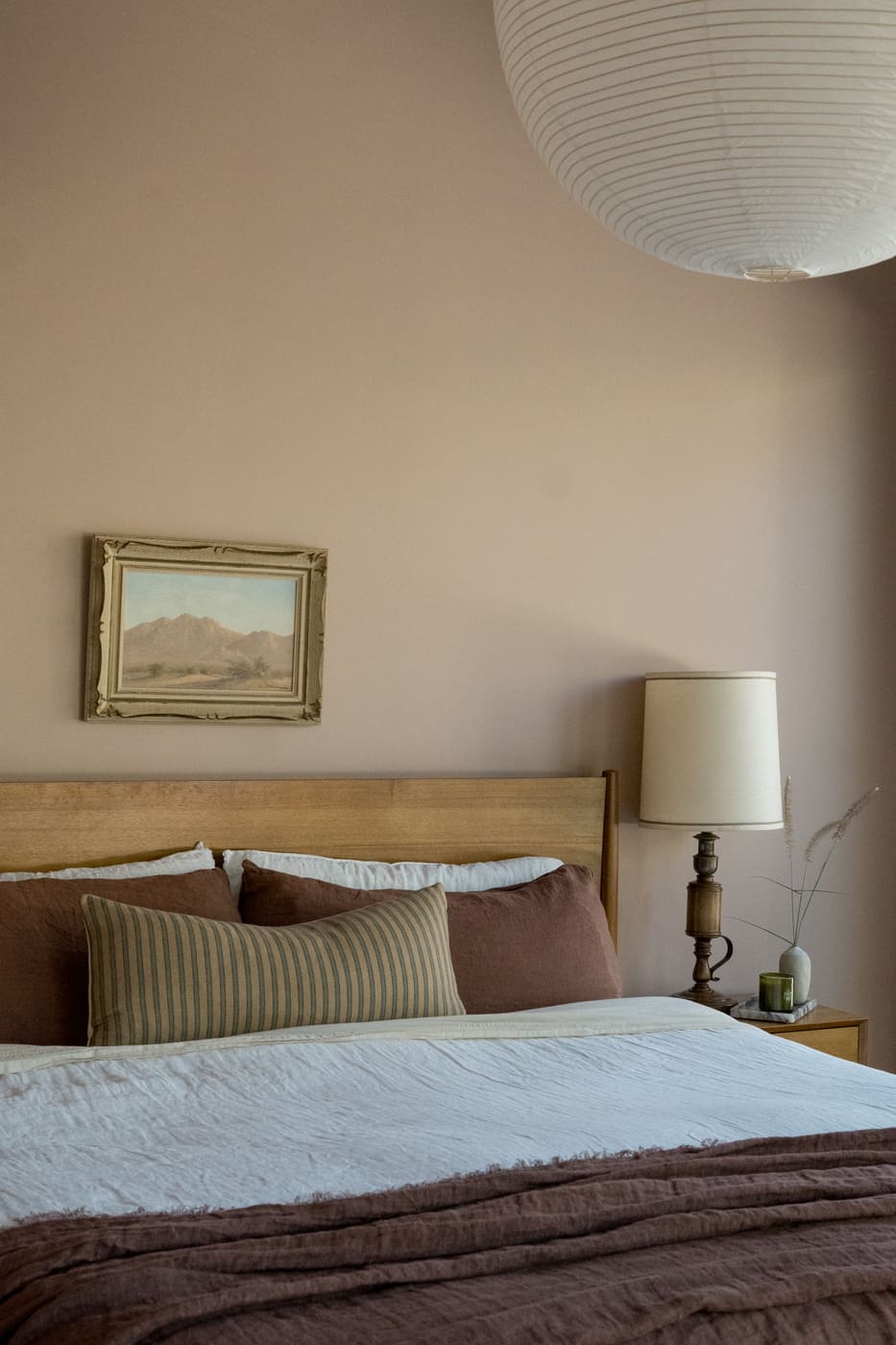 Cozy bedroom with wood bed, layered pillows, and artwork in Arvada, CO pop top renovation by Cillessen Construction