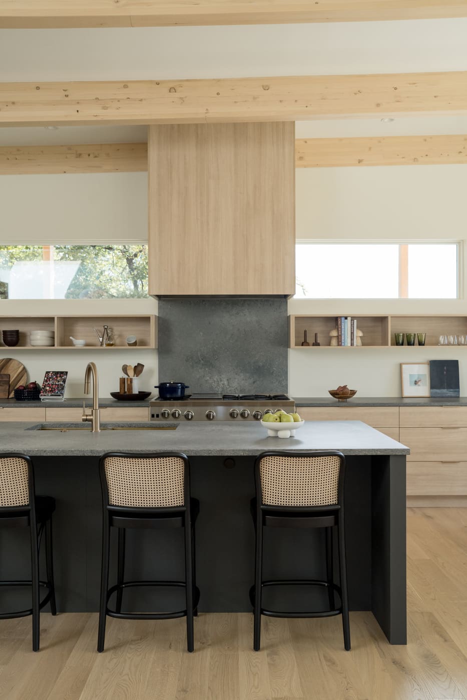 Kitchen island with seating, wood cabinetry, and range wall in Arvada, CO pop top renovation by Cillessen Construction