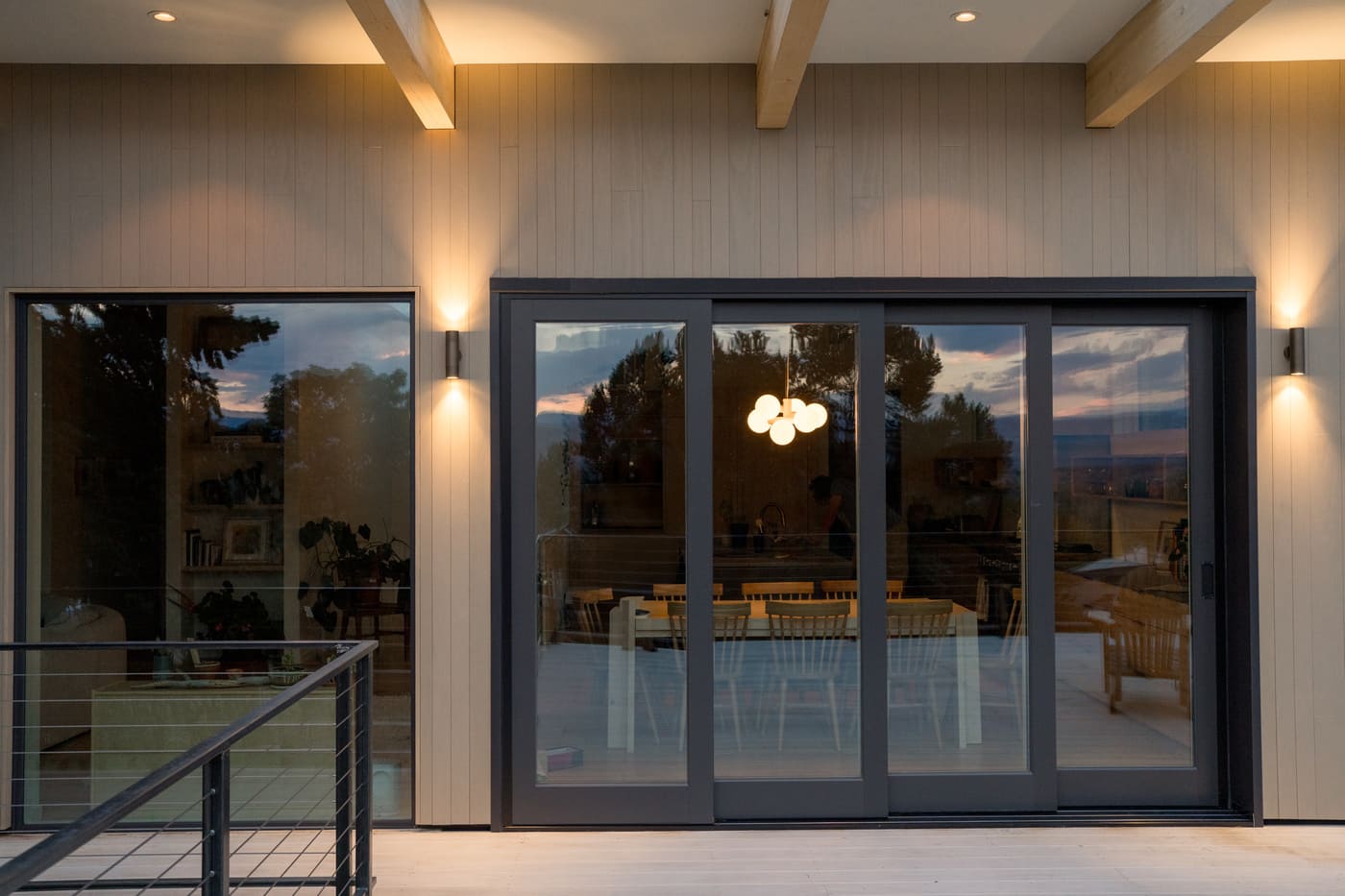 Sliding glass doors and deck with evening interior glow in Arvada, CO pop top renovation by Cillessen Construction
