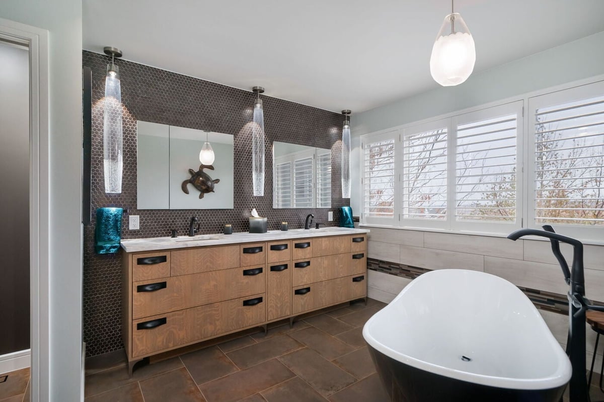 Littleton, CO whole home renovation bathroom with double vanity, freestanding tub, and modern lighting by Cillessen Construction