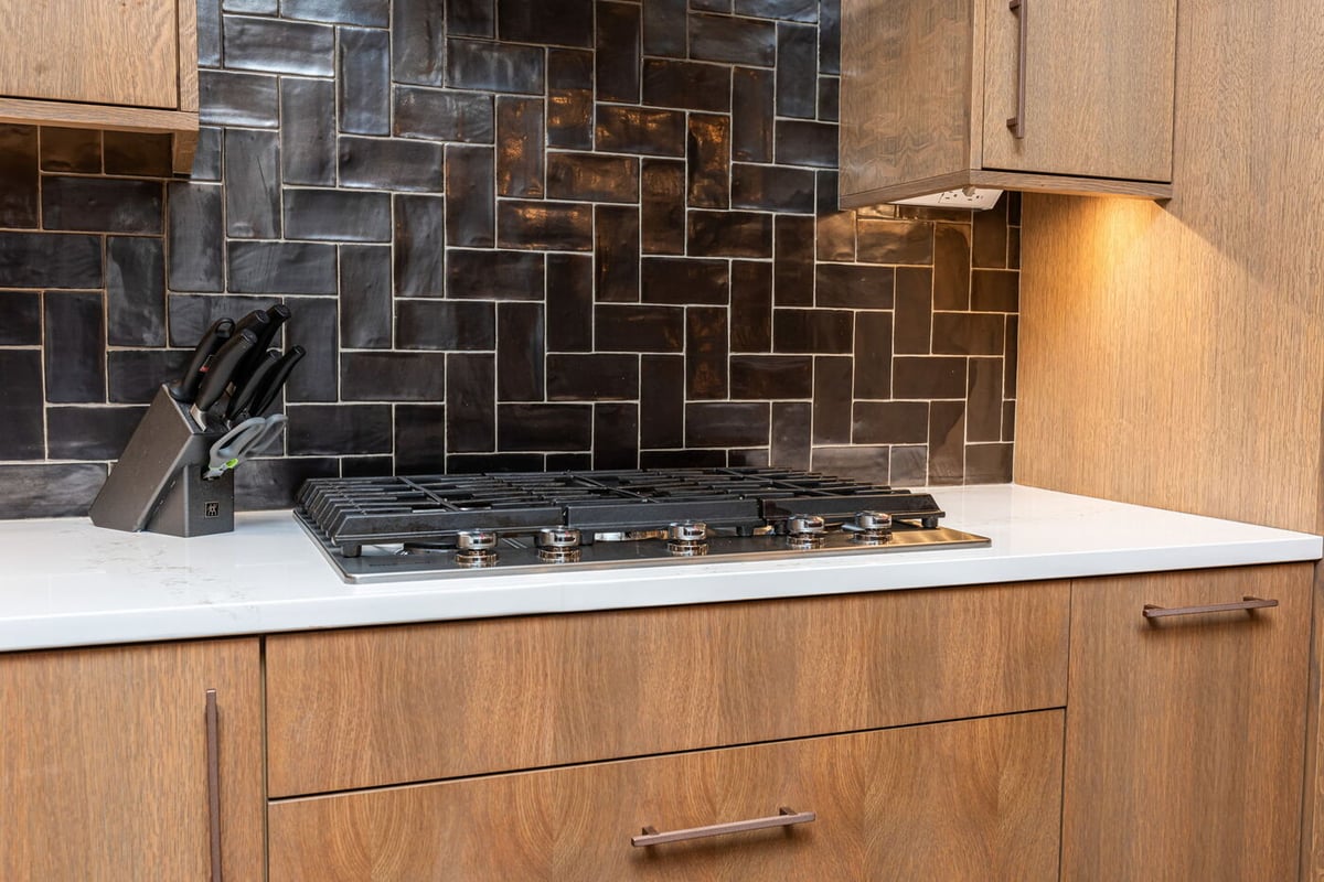 Littleton, CO whole home renovation kitchen with gas cooktop and dark tile backsplash by Cillessen Construction